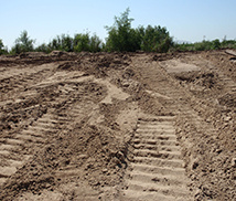 Fresh equipment tracks across a stripped construction site